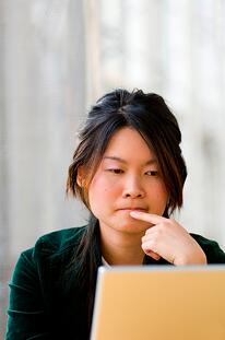 122576781_Young_Asian_university_student_working_on_laptop_computer.