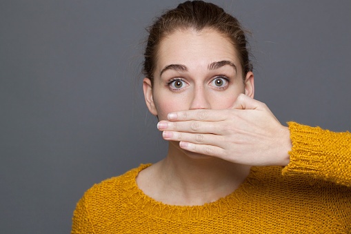 499145600 - woman covering mouth bad breath
