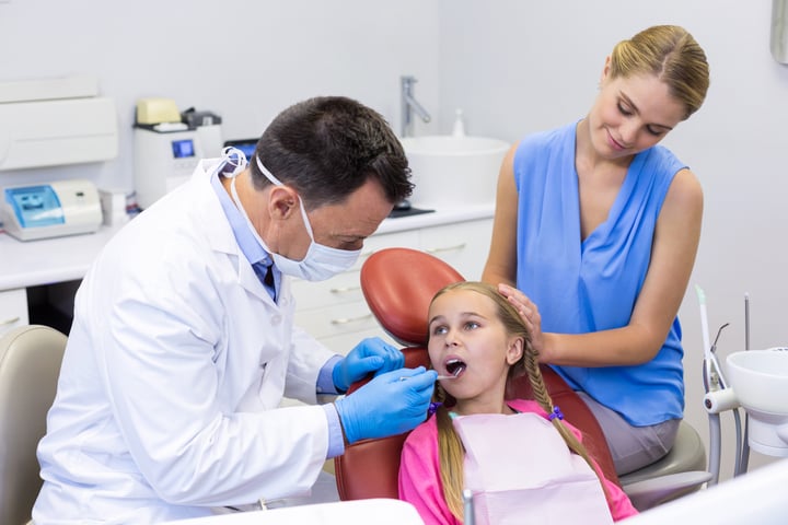 A girl with special needs at a dentist appointment with her mother 