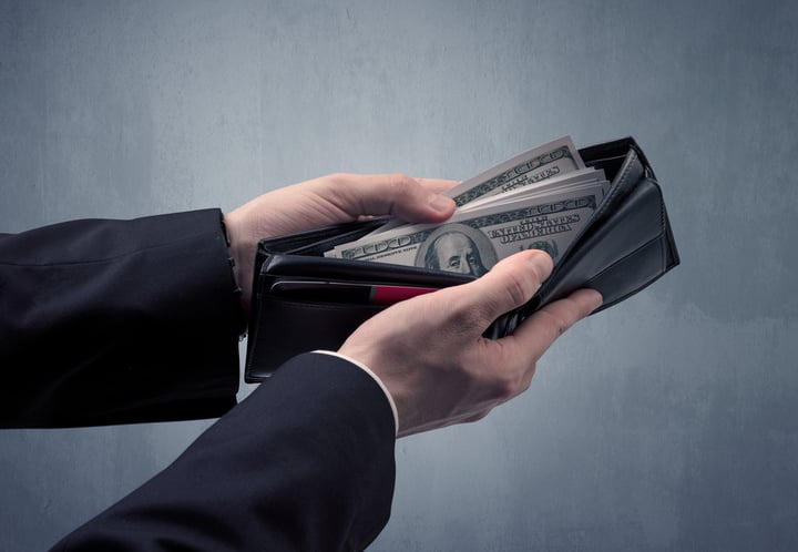 Businessmans hand in suit takes out dollar money from a wallet