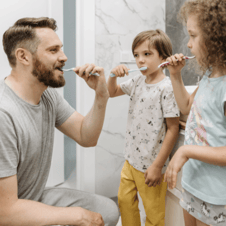 dad and kids brushing teeth