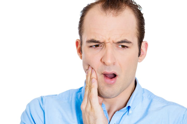 Closeup portrait of young man with sensitive tooth ache crown problem, suffering from pain, touching outside mouth with hand, isolated white background. Negative emotions, facial expression, feeling-1