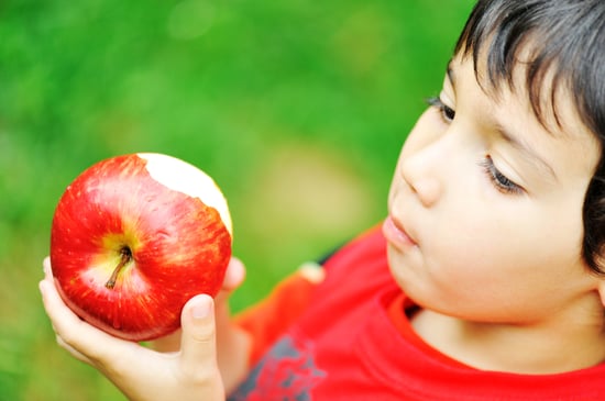 Cute kid holding red apple