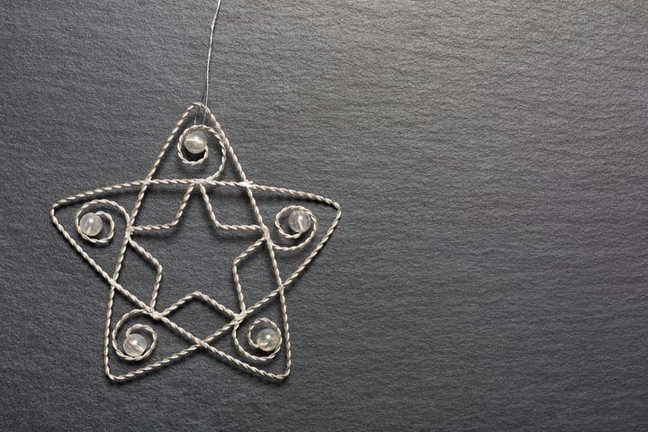 Delicate metal star Christmas decoration on a dark slate surface