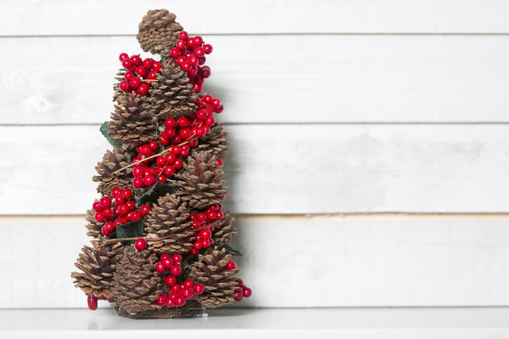 Delicate pinecone Christmas tree with red holly berries decoration