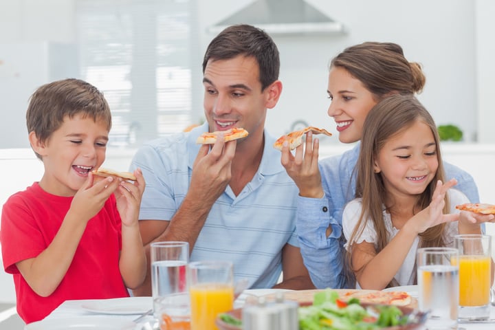 Happy family eating pizza slices for the dinner