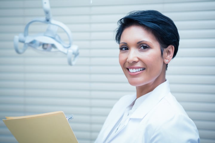 Portrait of smiling female dentist reading reports-1