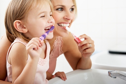 157740766_Mother_And_Daughter_Brushing_Teeth_Together