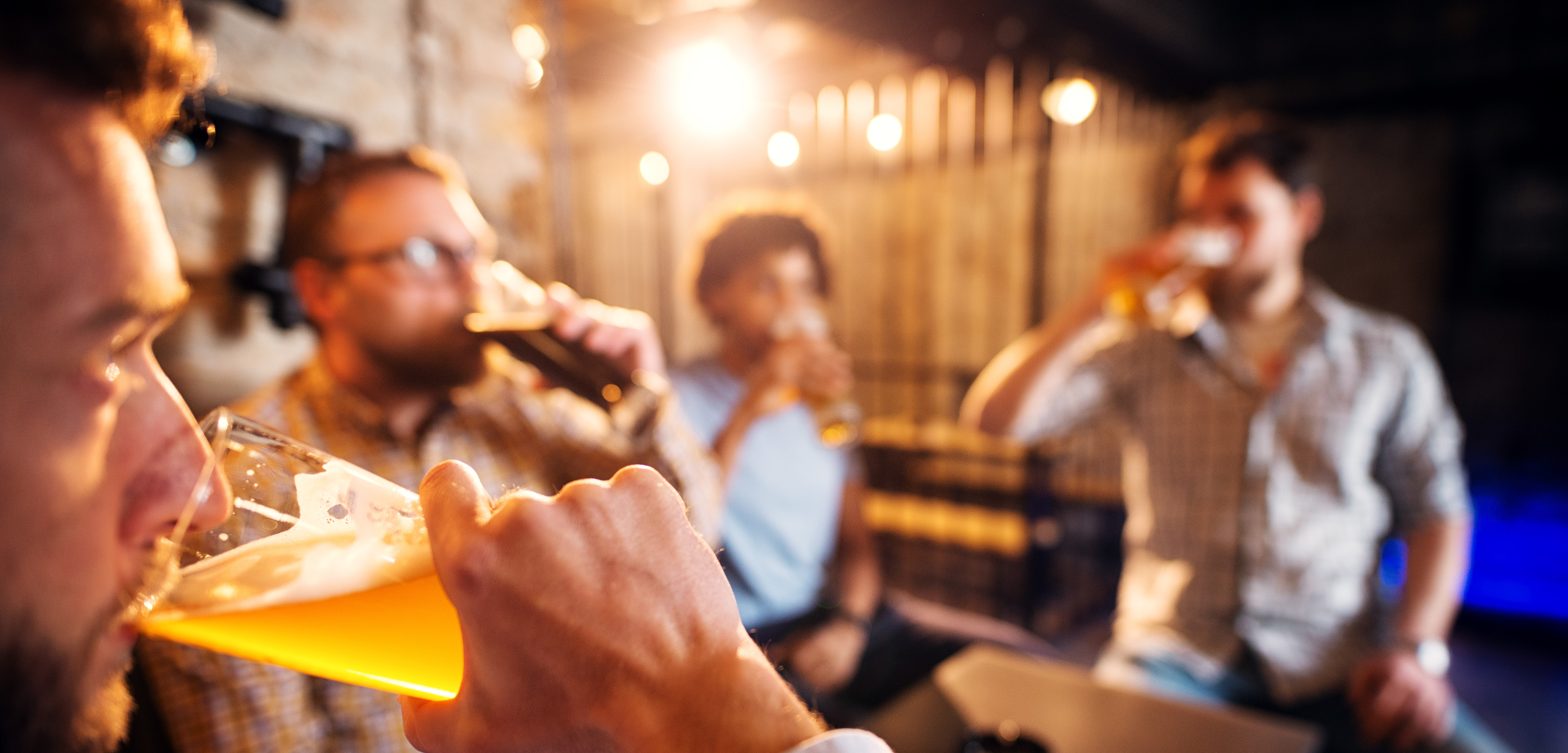 group of smiling friends drinking in a bar lounge