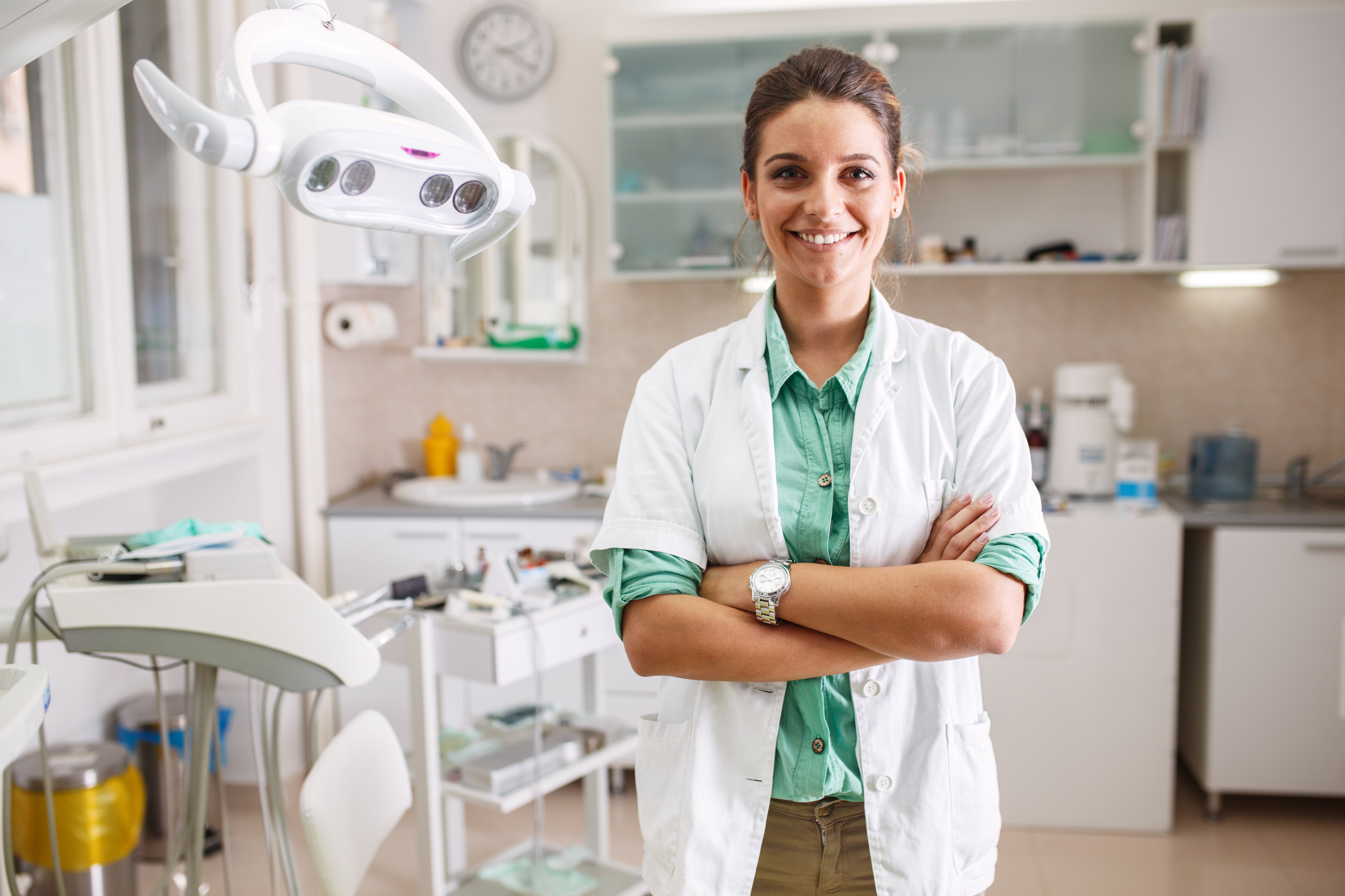 Smiling female dentist standing in her office