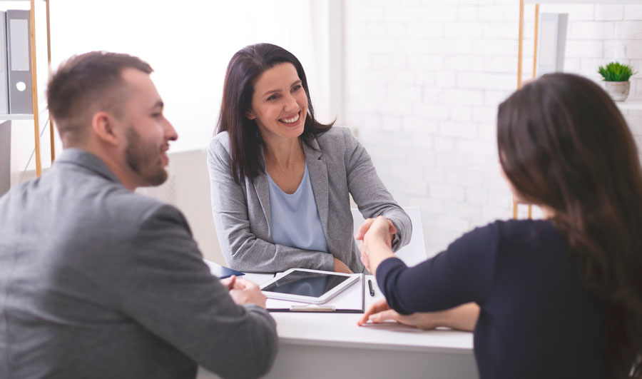 Smiling female insurance agent meeting with clients