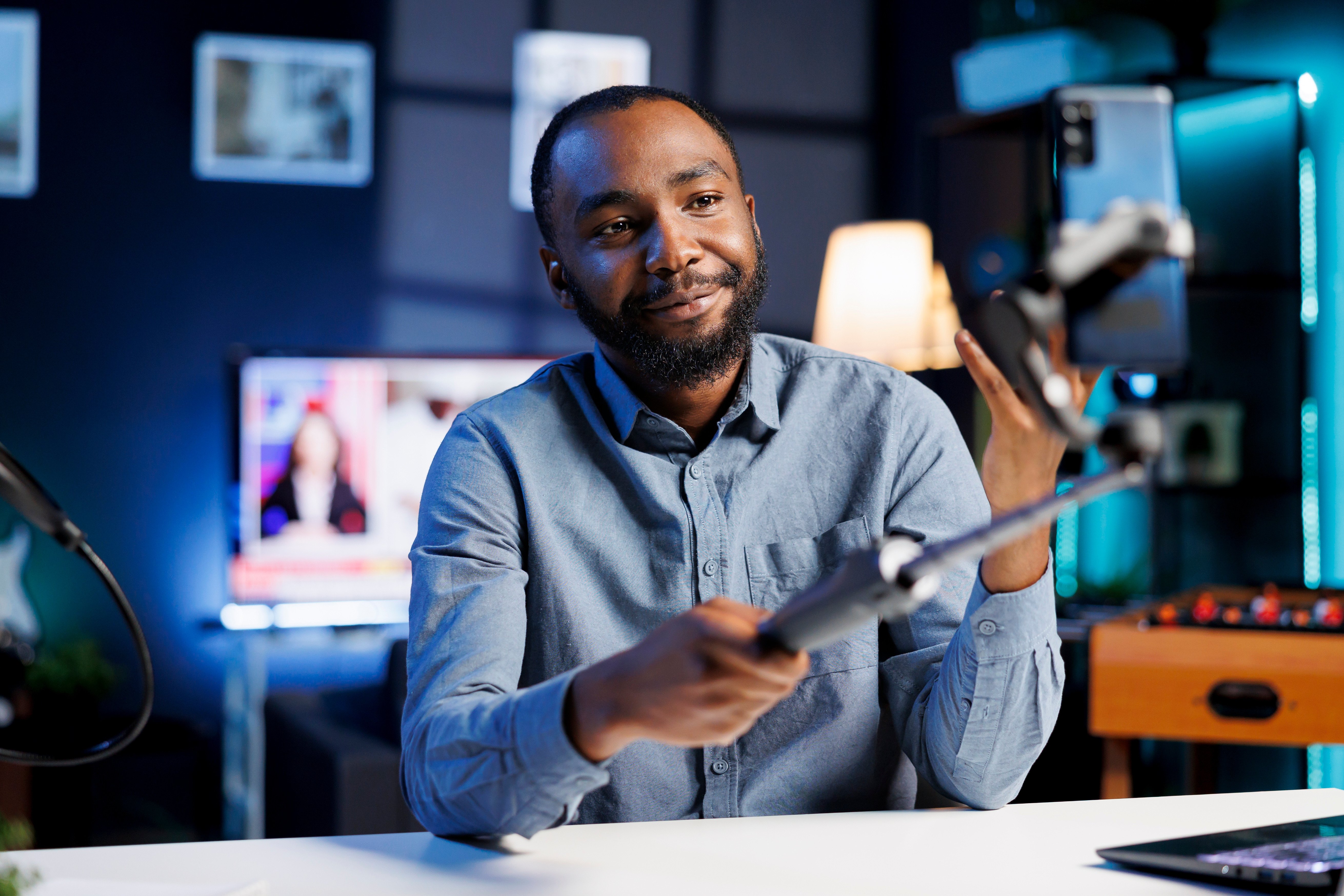 man in business casual attire filming an online video