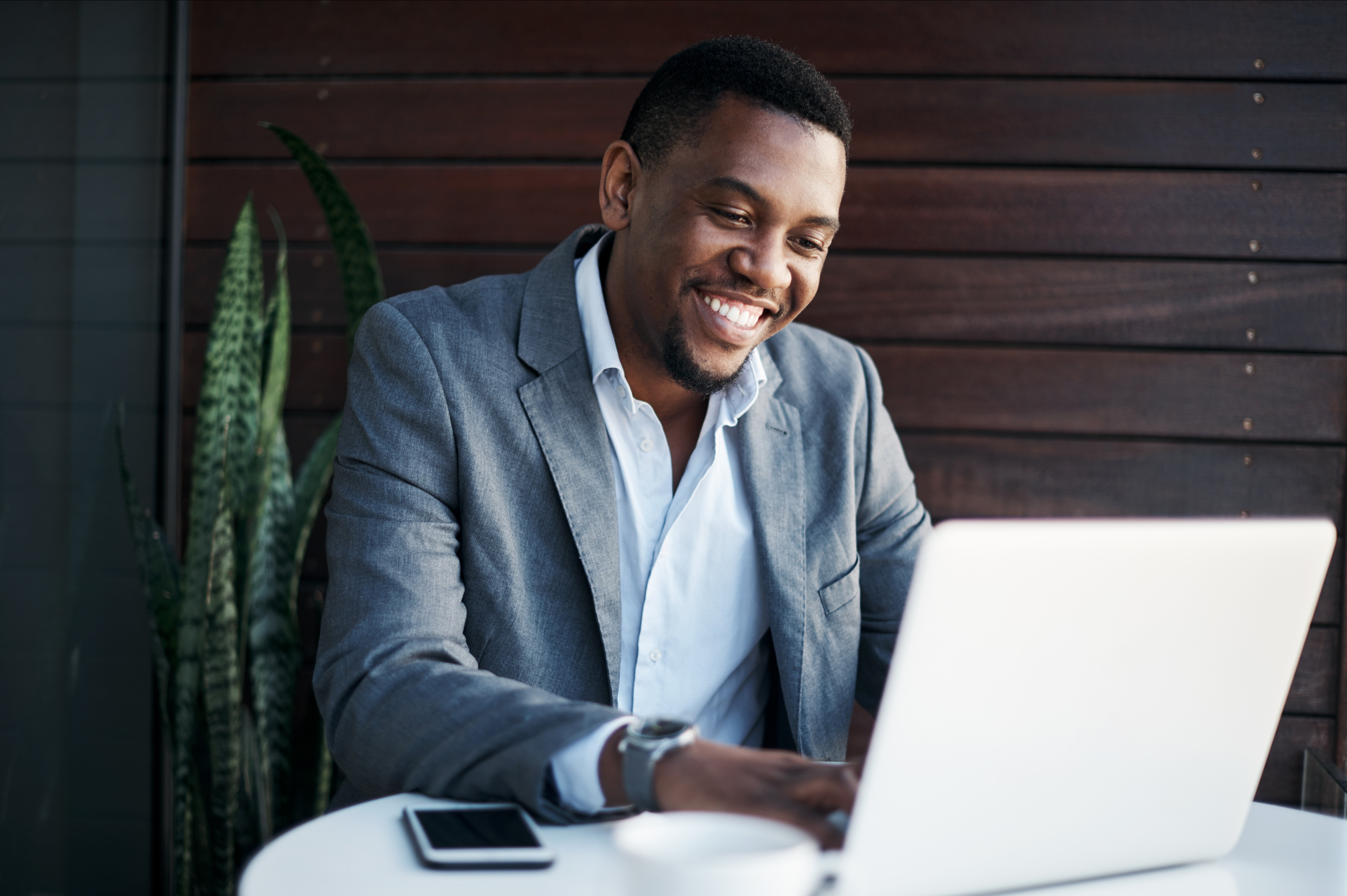 Smiling insurance agent sitting at a laptop