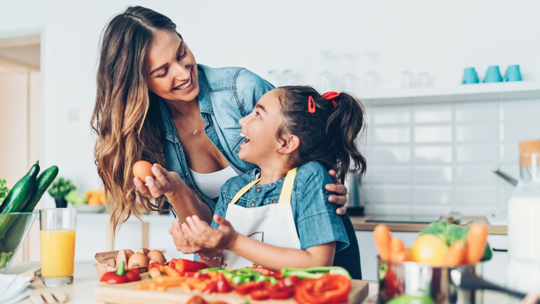 woman and little girl cooking in the kitchen, smiling