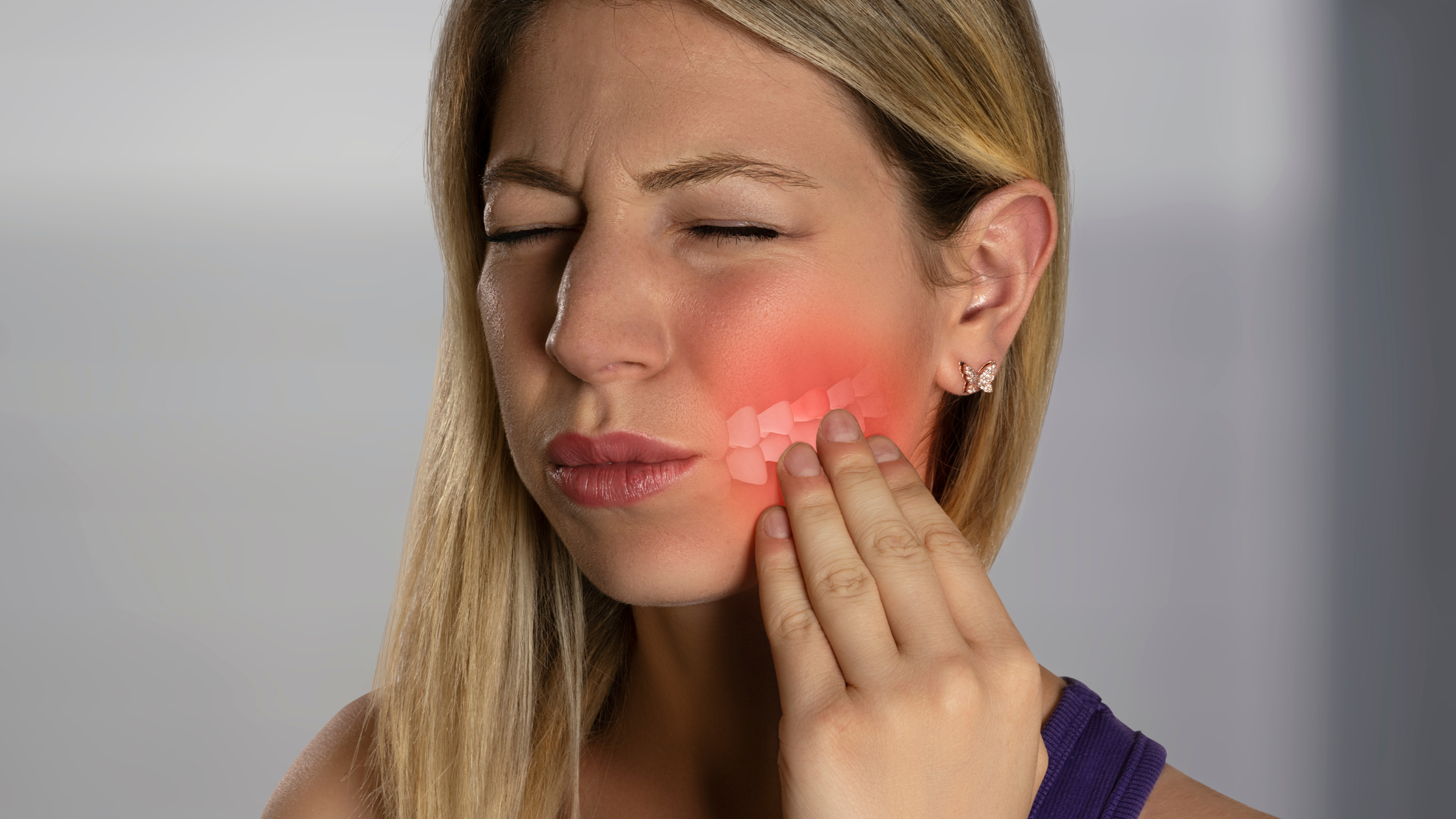 A woman experiencing a toothache/tooth pain.