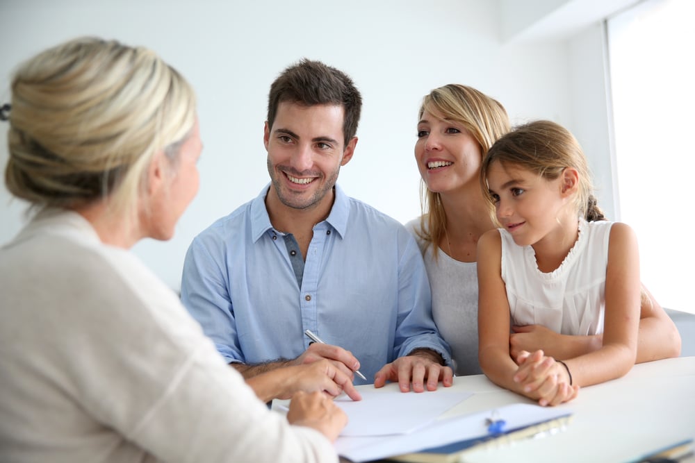 Female insurance agent with a smiling family