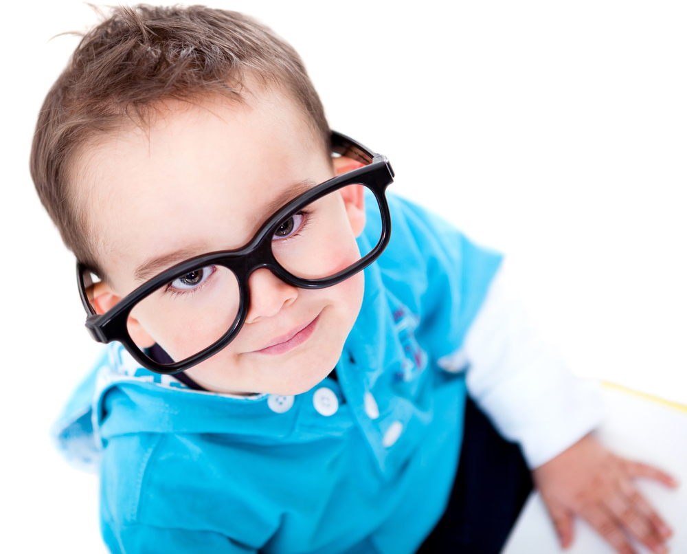 Small boy wearing oversized eyeglasses and smiling.