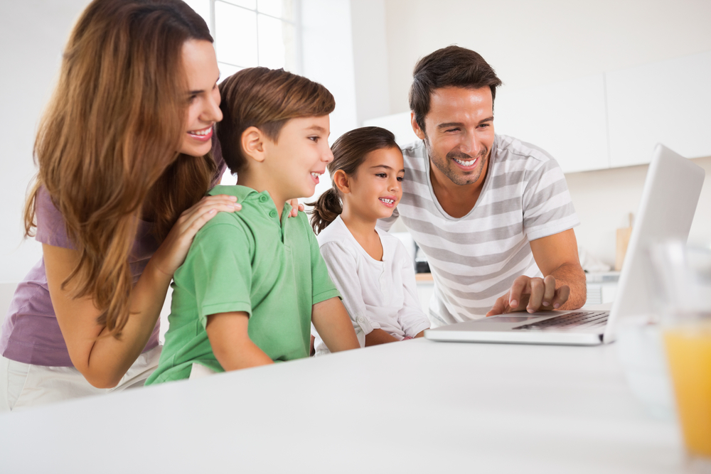 young family looking at a laptop