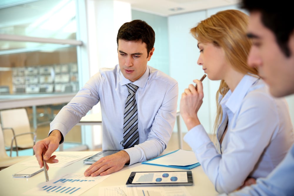 Business people sitting at a desk looking at paperwork