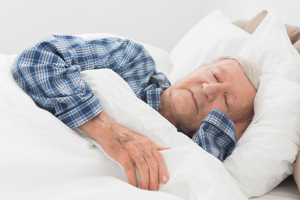 Image of an older man sleeping in a bed