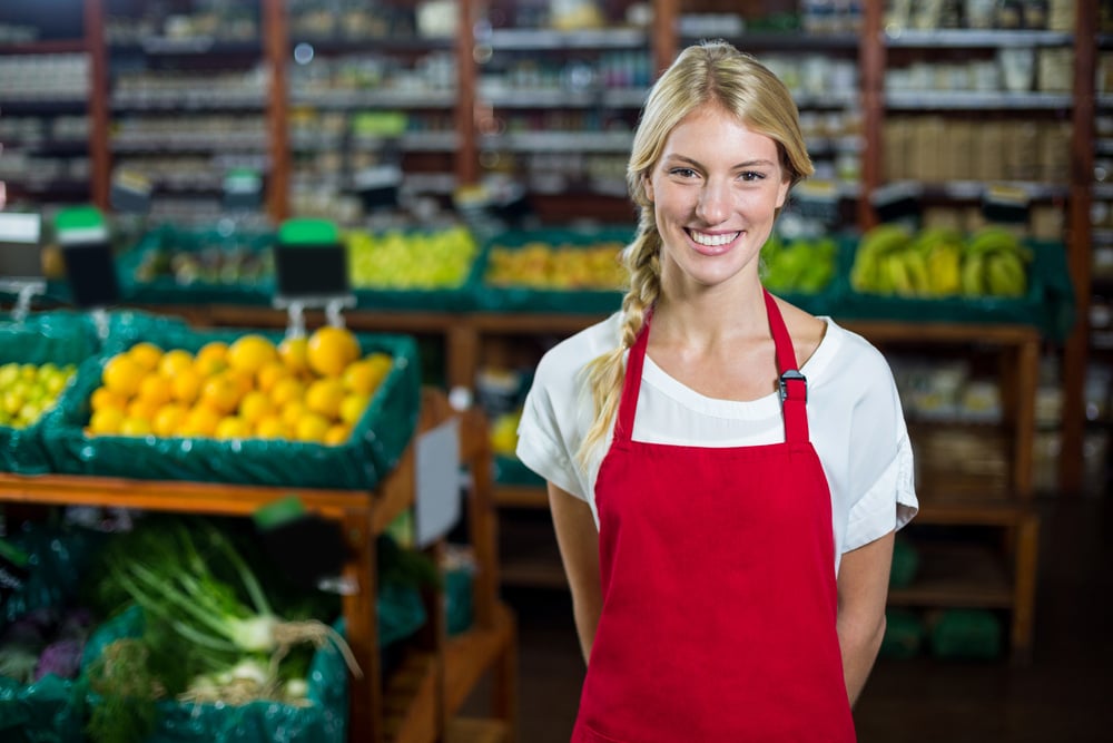 A smiling female grocery store worker