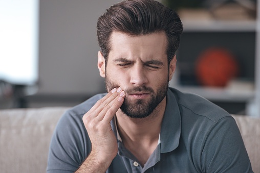 A man holding the side of his jaw in pain